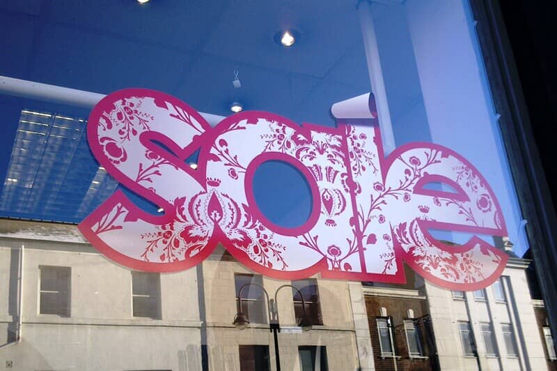 An image of a "Sale" sign on a storefront window.